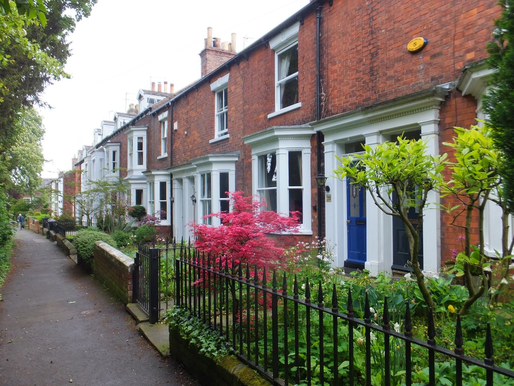 A row of British terraced homes with front gardens